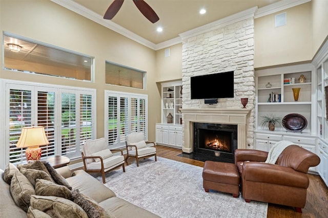 2319 Woodway Dr, Round Rock, TX 78681 - living room featuring ornamental molding, wood finished floors, a stone fireplace, a ceiling fan, and a high ceiling