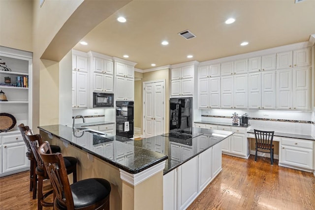 2319 Woodway Dr, Round Rock, TX 78681 - kitchen with black appliances, white cabinetry, light wood-type flooring, a peninsula, and recessed lighting