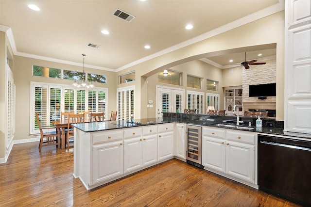 2319 Woodway Dr, Round Rock, TX 78681 - kitchen with black appliances, wine cooler, ceiling fan, arched walkways, and light wood-type flooring