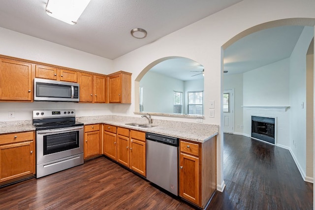 18111 Gallant St, Manor, TX 78653 - kitchen with stainless steel appliances, ceiling fan, dark wood-style floors, and brown cabinets