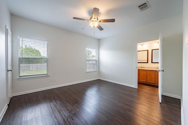 18111 Gallant St, Manor, TX 78653 - unfurnished bedroom with dark wood finished floors, a ceiling fan, and connected bathroom