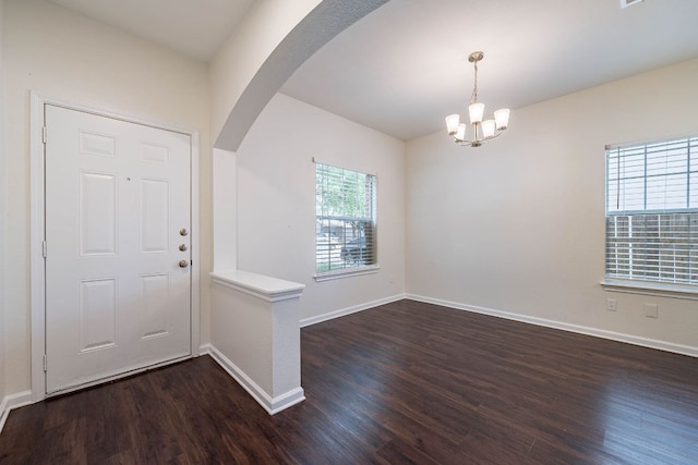 18111 Gallant St, Manor, TX 78653 - foyer entrance featuring arched walkways, dark wood finished floors, and a chandelier