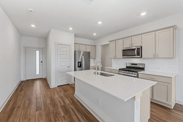 7514 Daves Landing Dr, Austin, TX 78724 - kitchen with appliances with stainless steel finishes, a center island with sink, dark wood-style floors, backsplash, and light countertops