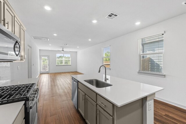 7514 Daves Landing Dr, Austin, TX 78724 - kitchen with appliances with stainless steel finishes, gray cabinetry, dark wood-style floors, plenty of natural light, and recessed lighting