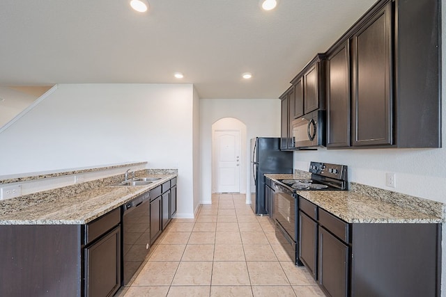 20016 Woodrow Wilson St, Manor, TX 78653 - kitchen with black appliances, arched walkways, dark brown cabinets, light tile patterned floors, and recessed lighting
