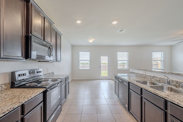 20016 Woodrow Wilson St, Manor, TX 78653 - kitchen featuring black appliances, dark brown cabinets, recessed lighting, light tile patterned floors, and light stone counters