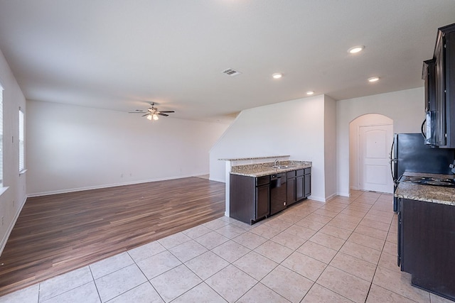 20016 Woodrow Wilson St, Manor, TX 78653 - kitchen featuring ceiling fan, arched walkways, light tile patterned flooring, recessed lighting, and freestanding refrigerator