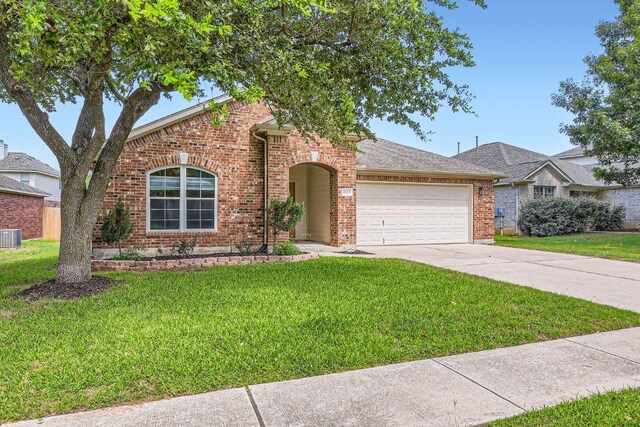9508 Castle Pines Dr, Austin, TX 78717 - view of front facade featuring an attached garage, a front yard, brick siding, and concrete driveway