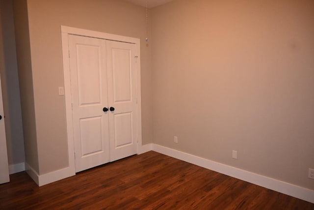 215 E 8th St, Elgin, TX 78621 - unfurnished bedroom with dark wood-style flooring and a closet