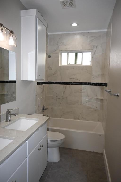 215 E 8th St, Elgin, TX 78621 - bathroom with double vanity, bathtub / shower combination, and tile patterned flooring