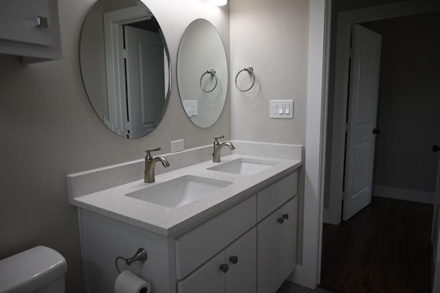 215 E 8th St, Elgin, TX 78621 - bathroom featuring double vanity and wood finished floors