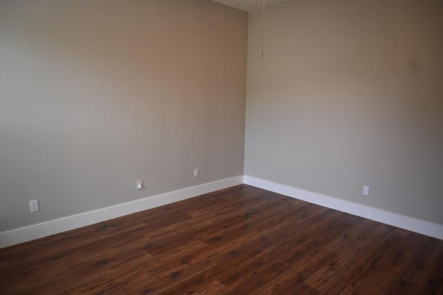 215 E 8th St, Elgin, TX 78621 - spare room with baseboards and dark wood-type flooring