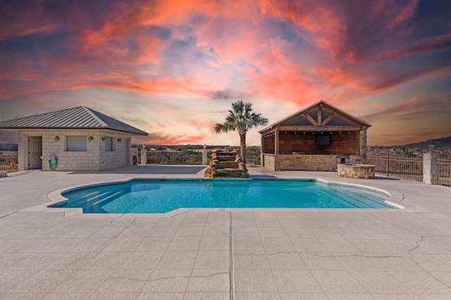 8300 Money Pit Rd, Killeen, TX 76542 - pool at dusk with a patio and a fireplace