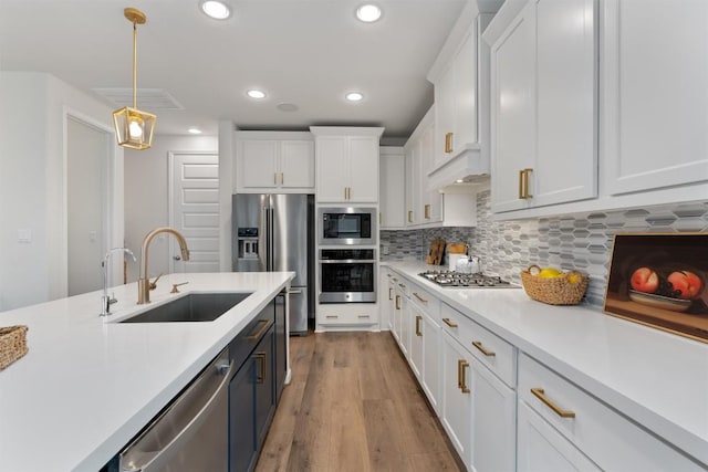 2437 Burberry Ln, Leander, TX 78641 - kitchen with stainless steel appliances, light countertops, white cabinetry, and recessed lighting