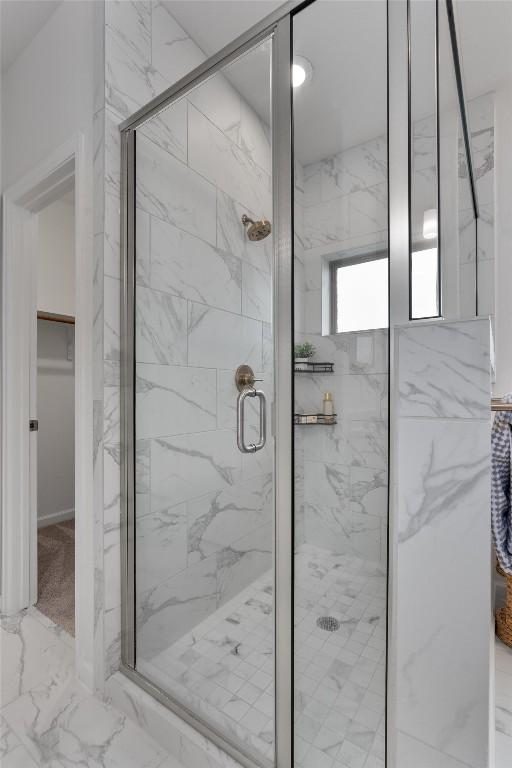 2437 Burberry Ln, Leander, TX 78641 - bathroom with a marble finish shower, a walk in closet, and marble look tile flooring