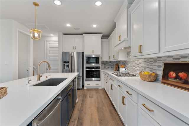 2437 Burberry Ln, Leander, TX 78641 - kitchen featuring appliances with stainless steel finishes, light countertops, white cabinets, recessed lighting, and pendant lighting