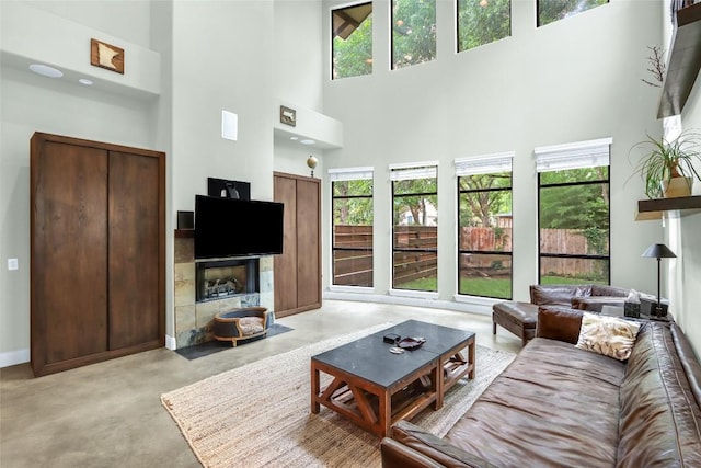 2312 Thornton Rd Unit B, Austin, TX 78704 - living area featuring concrete floors, a towering ceiling, and a tile fireplace