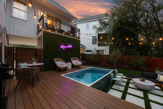 5703 Taunton Dr, Austin, TX 78723 - pool at dusk with a fenced backyard, a wooden deck, and outdoor lounge area