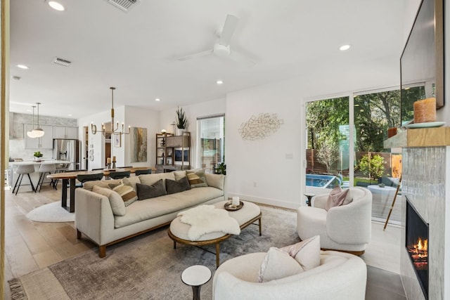 5703 Taunton Dr, Austin, TX 78723 - living area with a warm lit fireplace, recessed lighting, wood finished floors, ceiling fan, and a chandelier