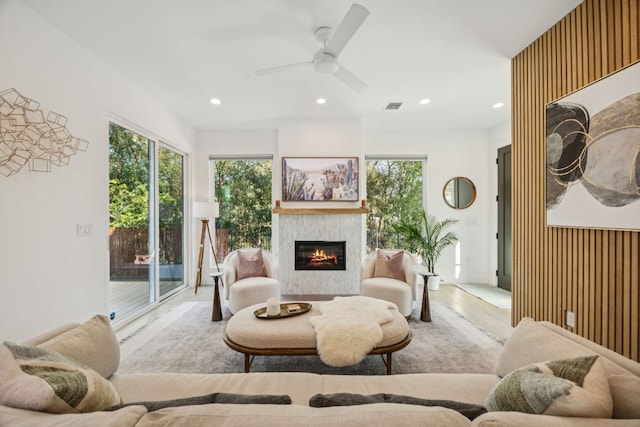 5703 Taunton Dr, Austin, TX 78723 - living room featuring a glass covered fireplace, ceiling fan, healthy amount of natural light, recessed lighting, and wood finished floors