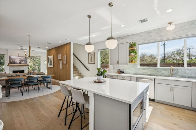 5703 Taunton Dr, Austin, TX 78723 - kitchen with stainless steel microwave, dishwasher, light wood finished floors, decorative backsplash, and recessed lighting
