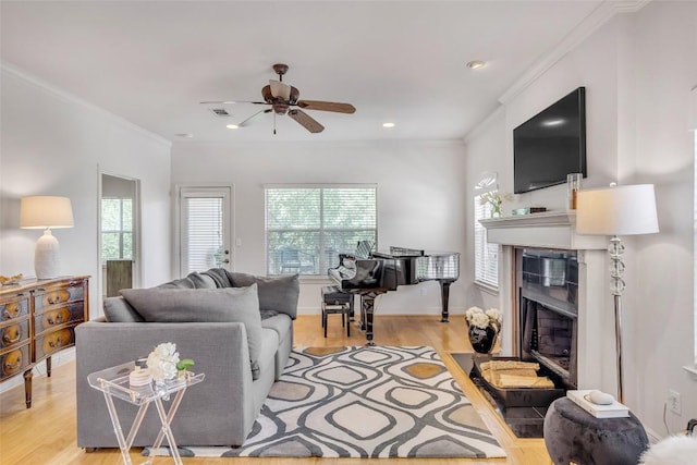 5511 Oakwood Cv Unit B, Austin, TX 78731 - living room featuring a fireplace, healthy amount of natural light, light wood-type flooring, a ceiling fan, and ornamental molding