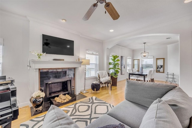5511 Oakwood Cv Unit B, Austin, TX 78731 - living room with a tile fireplace, crown molding, arched walkways, ceiling fan, and recessed lighting