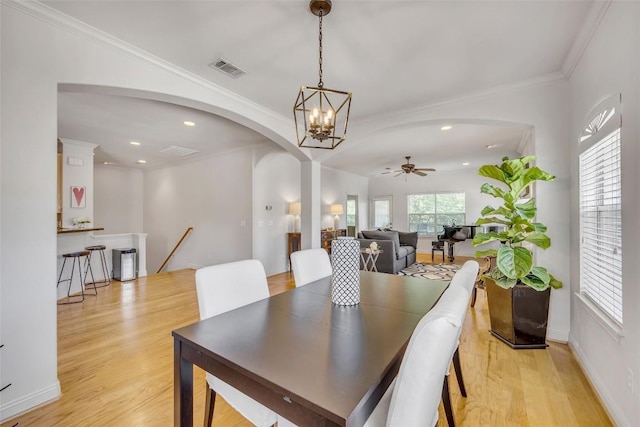 5511 Oakwood Cv Unit B, Austin, TX 78731 - dining space featuring arched walkways, light wood finished floors, ceiling fan, ornamental molding, and a chandelier