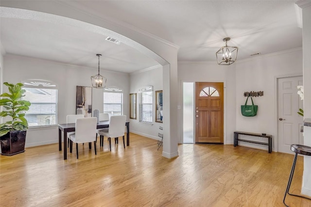5511 Oakwood Cv Unit B, Austin, TX 78731 - entryway featuring a chandelier, arched walkways, light wood-style flooring, and crown molding