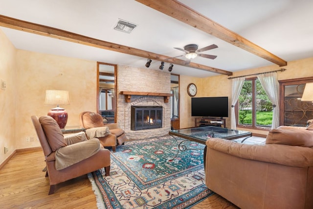 11923 Brookwood Cir, Austin, TX 78750 - living room featuring wood finished floors, beamed ceiling, a fireplace, and ceiling fan