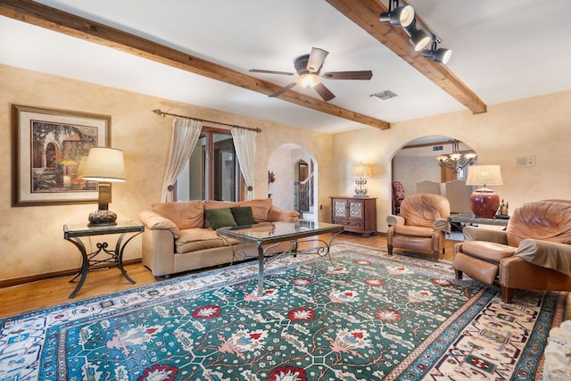 11923 Brookwood Cir, Austin, TX 78750 - living room featuring arched walkways, wood finished floors, beam ceiling, ceiling fan, and a chandelier