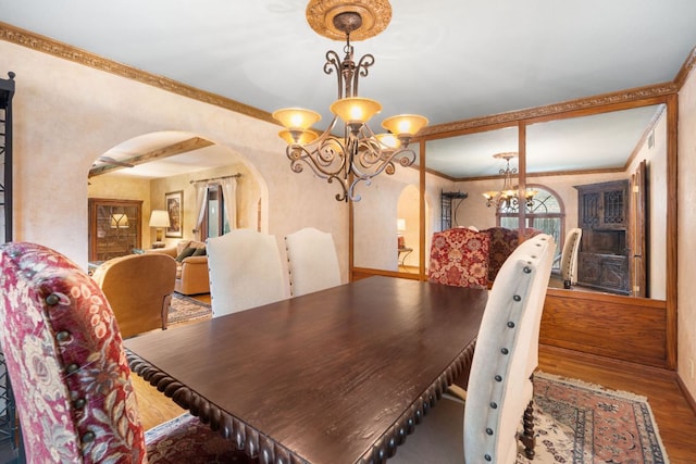 11923 Brookwood Cir, Austin, TX 78750 - dining area featuring arched walkways, a chandelier, wood finished floors, and crown molding
