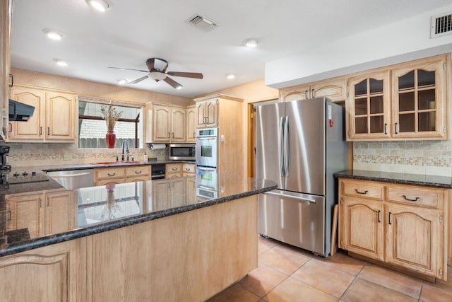 11923 Brookwood Cir, Austin, TX 78750 - kitchen featuring stainless steel appliances, light brown cabinets, dark stone countertops, a ceiling fan, and glass insert cabinets