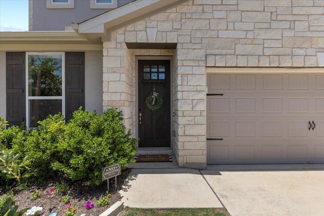 496 Sawtooth Mountain Way, Dripping Springs, TX 78620 - entrance to property with stone siding, driveway, and a garage
