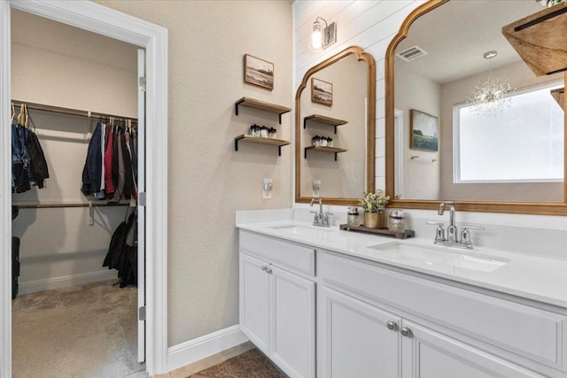 496 Sawtooth Mountain Way, Dripping Springs, TX 78620 - bathroom with double vanity, a spacious closet, and a chandelier