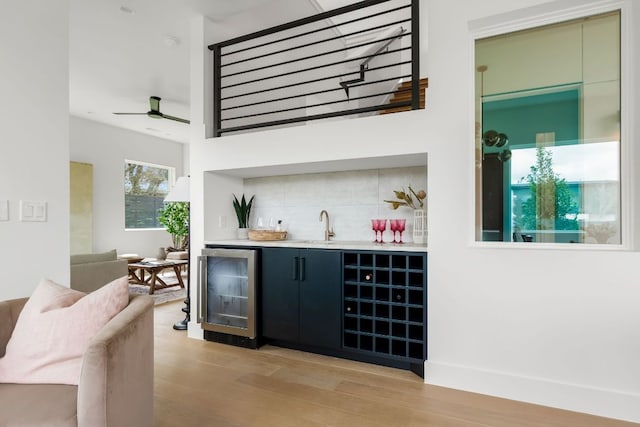 1703 Miami Dr, Austin, TX 78733 - indoor wet bar featuring beverage cooler, light wood finished floors, backsplash, and a ceiling fan