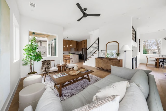 1703 Miami Dr, Austin, TX 78733 - living room with light wood-type flooring, ceiling fan, and stairway