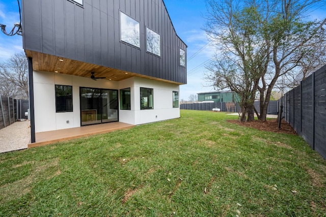 1703 Miami Dr, Austin, TX 78733 - back of property with board and batten siding, ceiling fan, a fenced backyard, and a patio