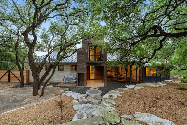 4904 Old Bee Caves Rd, Austin, TX 78746 - back of house with a standing seam roof, a balcony, a metal roof, and a patio