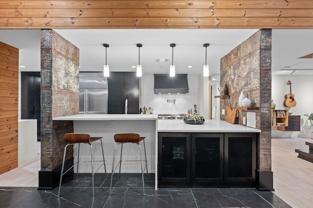 4904 Old Bee Caves Rd, Austin, TX 78746 - bar with stainless steel built in fridge, wall chimney range hood, marble finish flooring, and decorative light fixtures