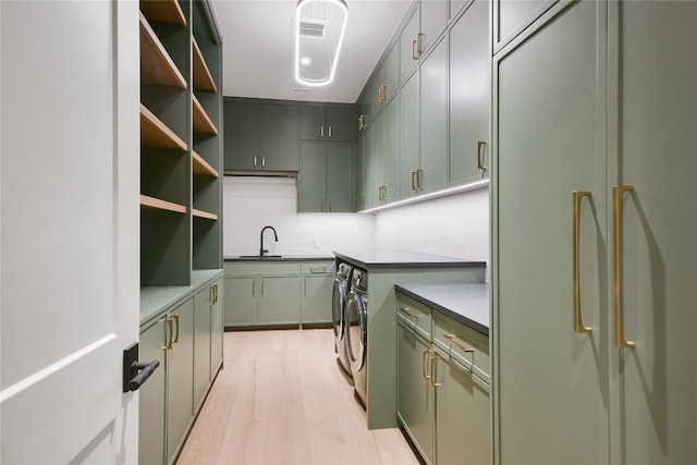 5217 S Scout Island Cir, Austin, TX 78731 - kitchen with fridge, washing machine and clothes dryer, light wood-type flooring, green cabinets, and backsplash