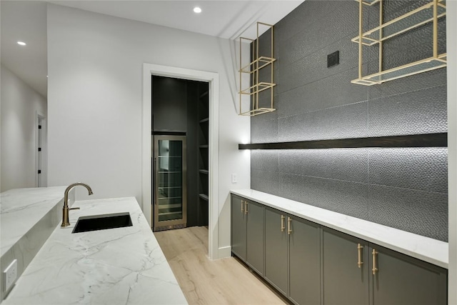 5217 S Scout Island Cir, Austin, TX 78731 - kitchen with wine cooler, gray cabinets, light wood finished floors, light stone counters, and recessed lighting