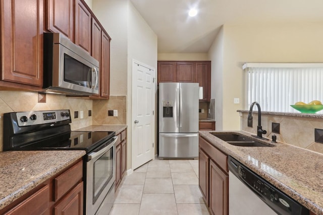 7233 Menchaca Rd Unit 22, Austin, TX 78745 - kitchen with stainless steel appliances, decorative backsplash, light stone counters, and light tile patterned floors