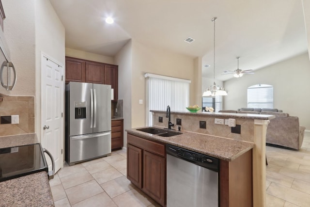 7233 Menchaca Rd Unit 22, Austin, TX 78745 - kitchen featuring appliances with stainless steel finishes, open floor plan, decorative backsplash, a ceiling fan, and light tile patterned floors