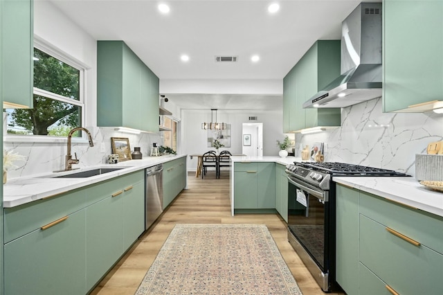 2114 Vanderbilt Ln, Austin, TX 78723 - kitchen featuring appliances with stainless steel finishes, wall chimney exhaust hood, green cabinets, and recessed lighting