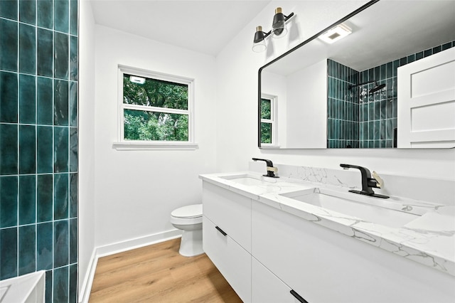 2114 Vanderbilt Ln, Austin, TX 78723 - full bathroom featuring double vanity, a tile shower, and wood finished floors