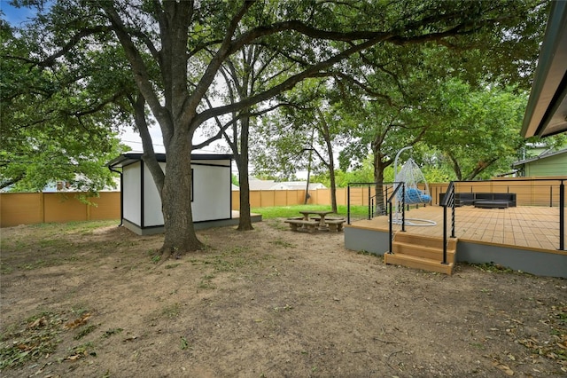 2114 Vanderbilt Ln, Austin, TX 78723 - fenced backyard with a wooden deck, a storage unit, and a fire pit