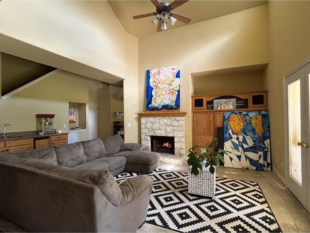 12304 Triple Creek Cir, Dripping Springs, TX 78620 - living area with a ceiling fan, high vaulted ceiling, a stone fireplace, and light tile patterned floors