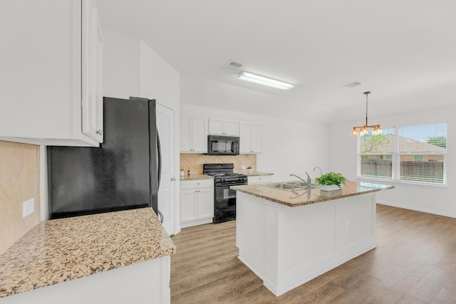 608 Silver Wing Dr, Austin, TX 78725 - kitchen featuring black appliances, light wood finished floors, backsplash, and white cabinets
