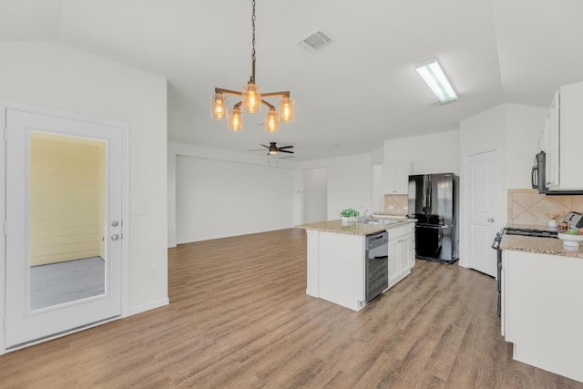608 Silver Wing Dr, Austin, TX 78725 - kitchen featuring black appliances, a chandelier, backsplash, white cabinetry, and lofted ceiling